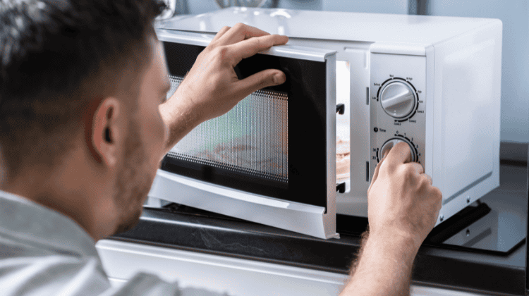 homme qui nettoie son micro-ondes